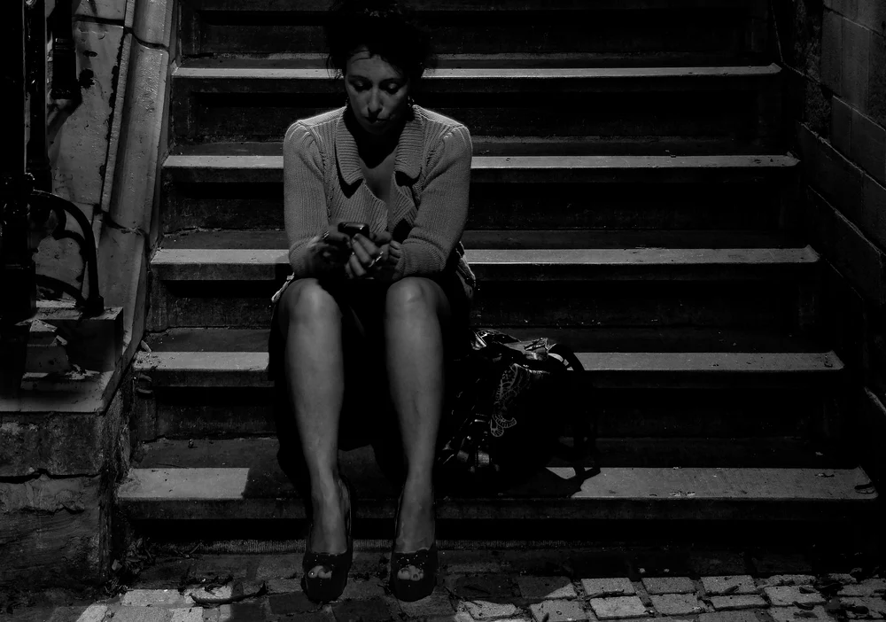 Contemplative Woman Sitting on Stairs at Night