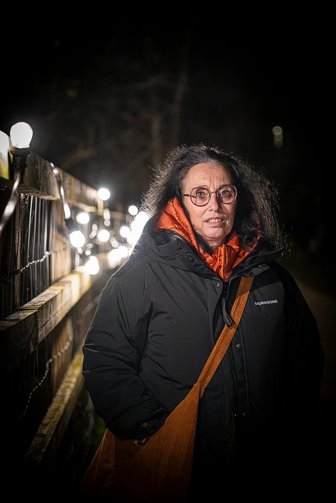 Heidi in Winter Coat with String Lights at Night