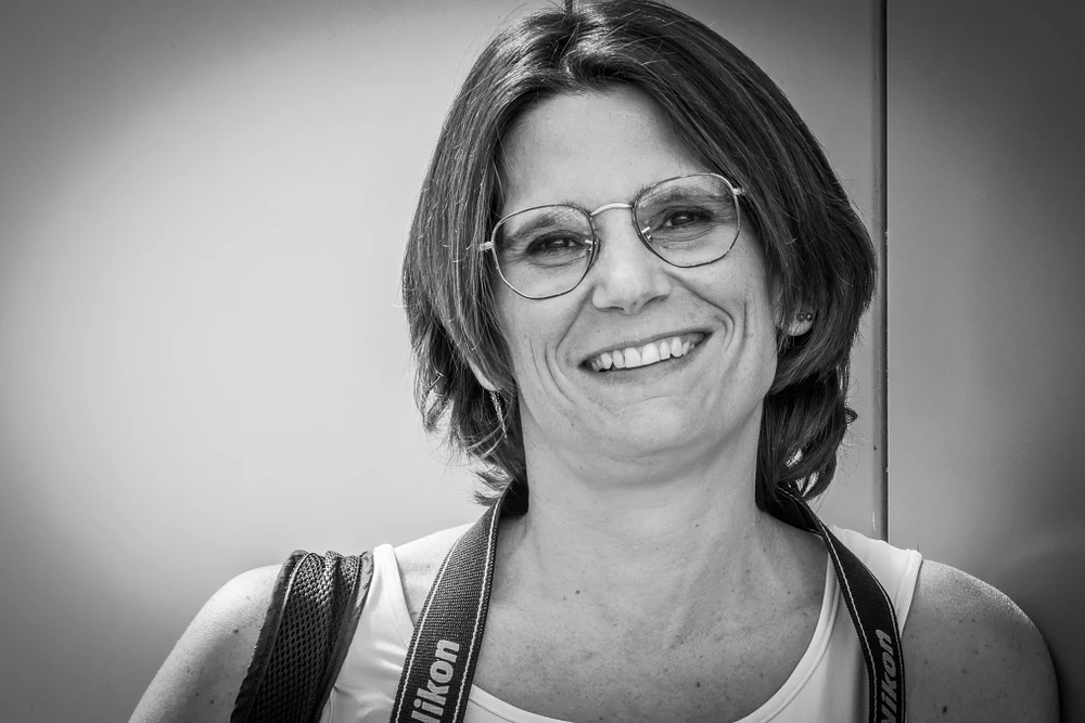 Captivating Portrait of a Smiling Woman with a Camera
