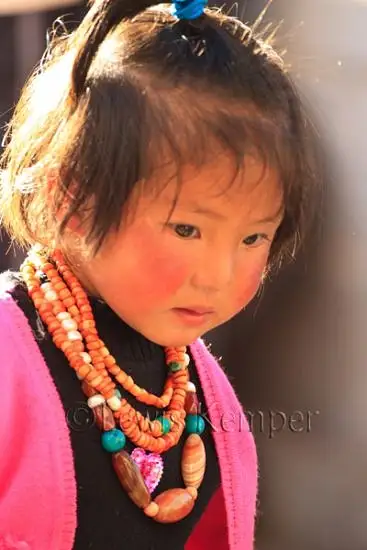 Tibetan child in prayer by Lewis Kemper