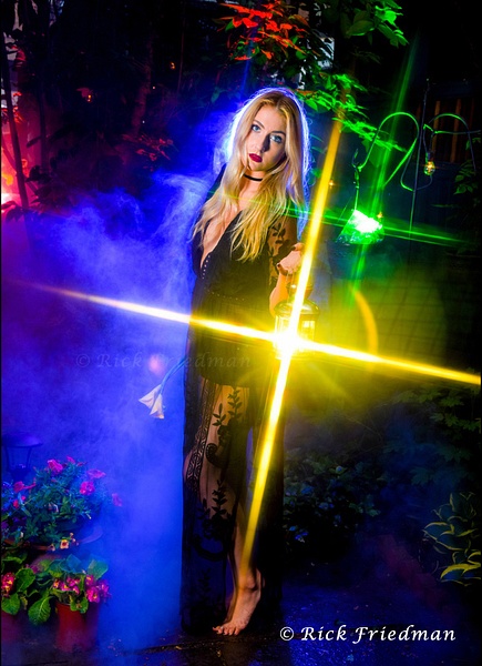 Model with long blond hair holding a lantern  with star light beams  outside with lots of color and smoke by Rick Friedman - Models - Rick Friedman Photography