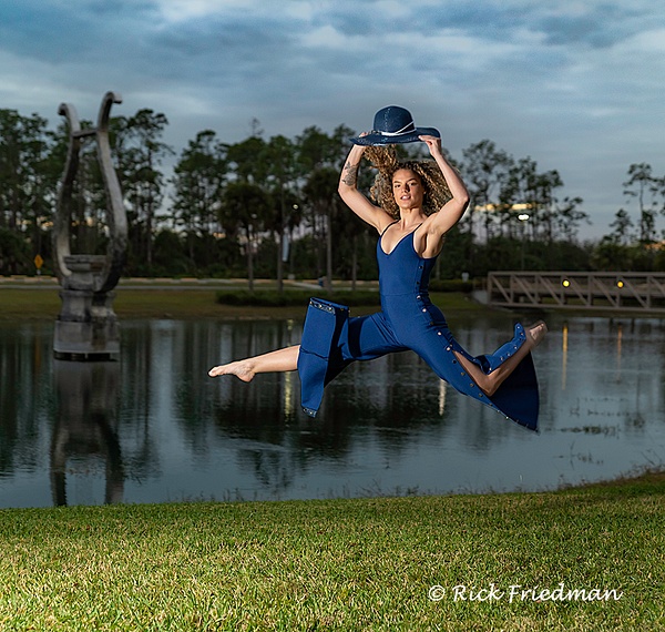 Model in blue with blue hat leaping by a pond in Florida by Rick Friedman - Rick Friedman Photography 