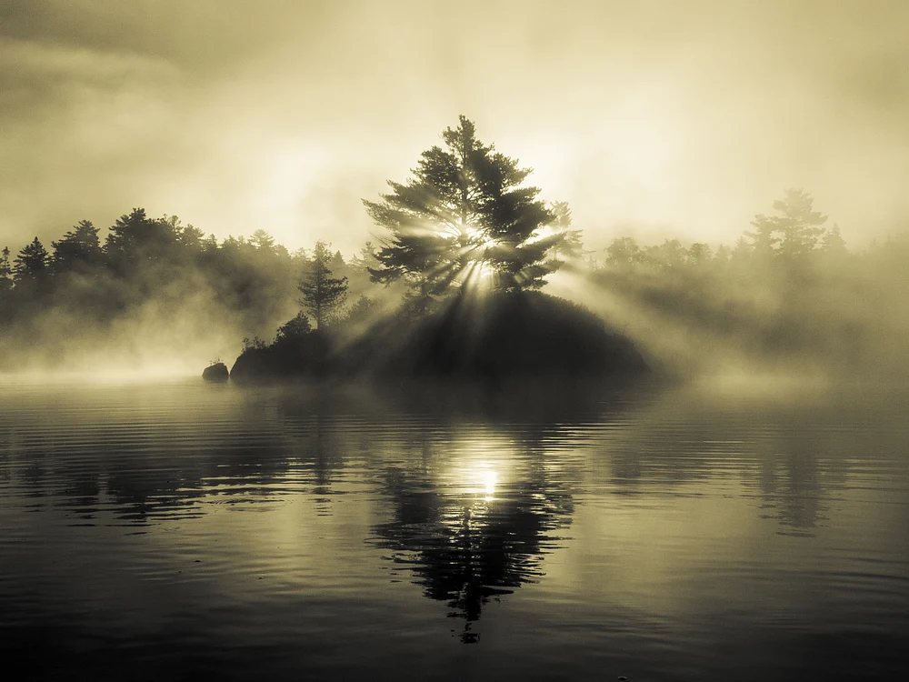 Misty Island Silhouette with Radiant Sunbeams