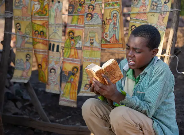 Young man studying his religious lesson, Ethiopia by...