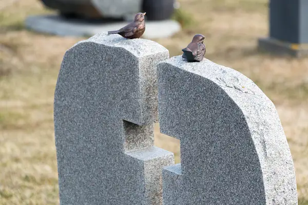Small bird figurines grace many headstones by Willis...