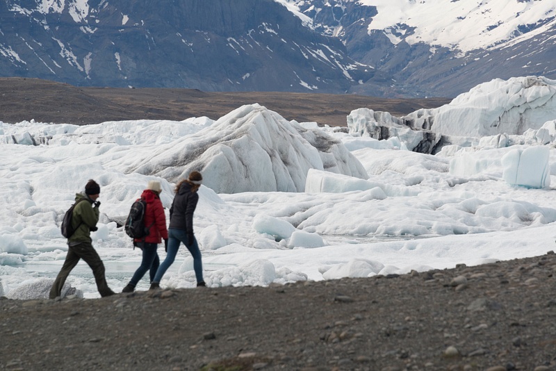 Excited hikers skirting the ice-filled lagoon