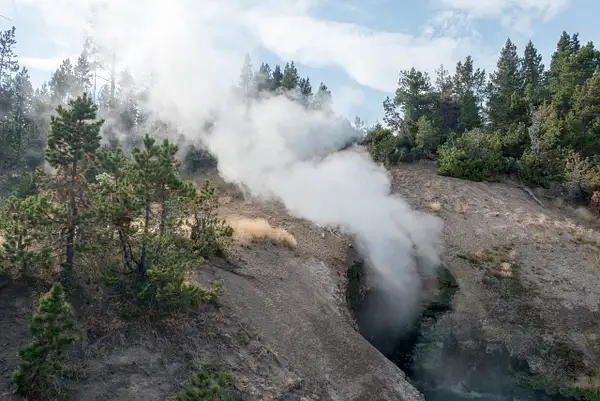 Steam rising over the hill from Dragon Mouth Spring by...