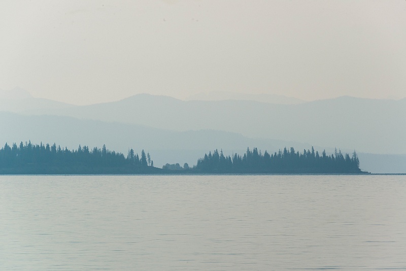 Morning mist hovers over small islands in Yellowstone Lake