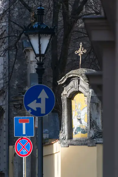 Sun hitting different signs near the gate to Szent...