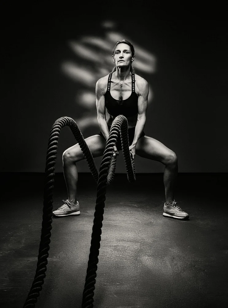 Powerful Woman Training with Battle Ropes in Black and White