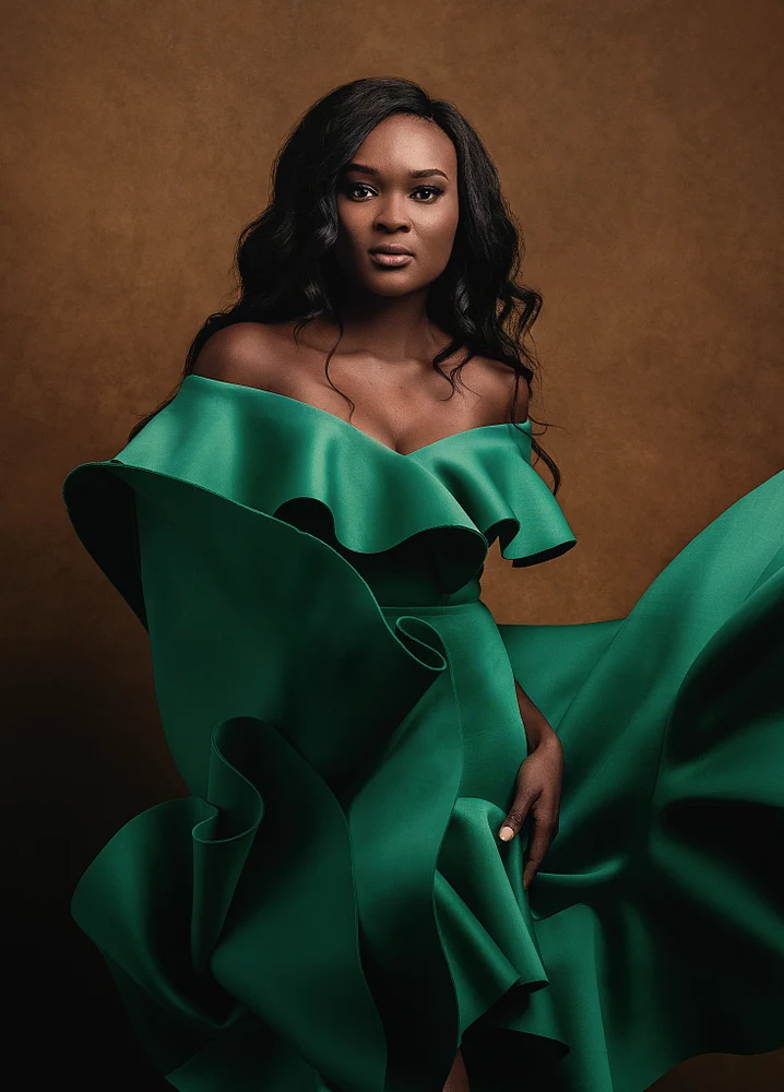 Elegant Woman in Green Ruffled Dress Against Brown Background