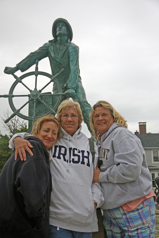 The girls in front of the famous Gloucester fisherman statue