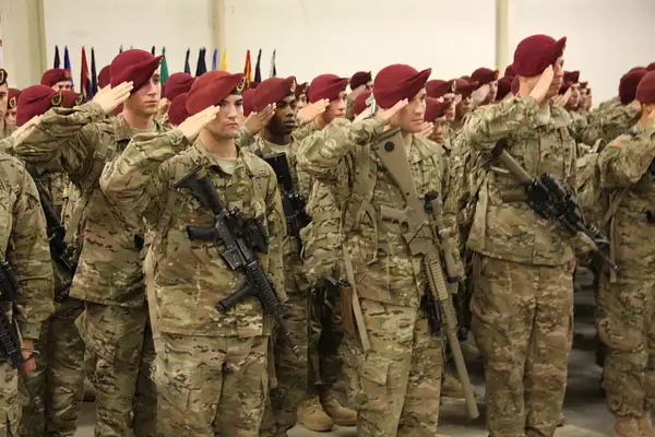Paratroopers salute the colors as the National Anthem is...