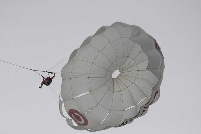 A parasailer floats above the beach