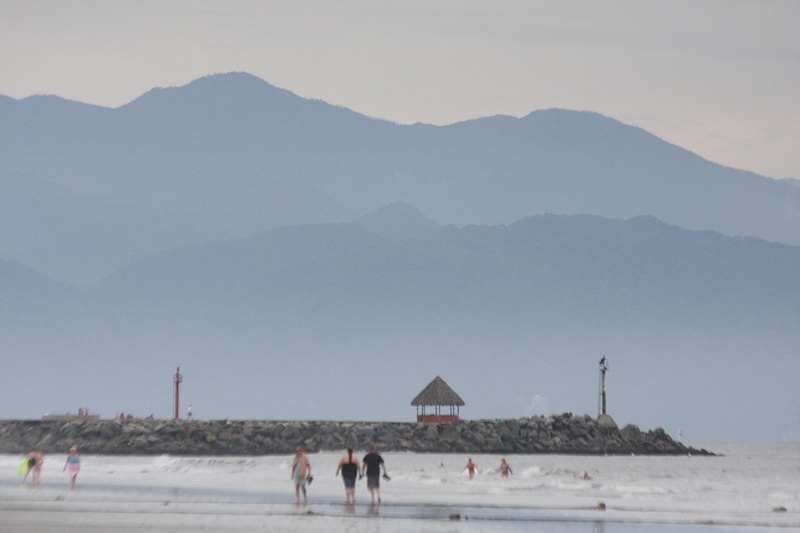 An afternoon stroll on the beach. The Sierra Madre towers over the jetty at the marina's entrance