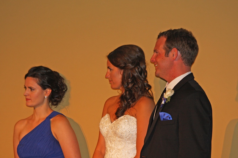 The Maid of Honor and Newlyweds look on as Joe delivers his speech