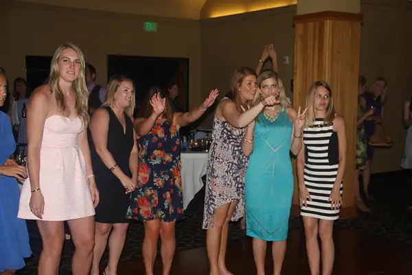 Single ladies eagerly await the bouquet toss by...