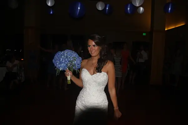 The bride prepares to toss the bouquet by...