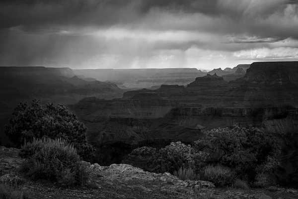 Black-and-white photograph of a dark storm forming over the Grand Canyon in Arizona.
