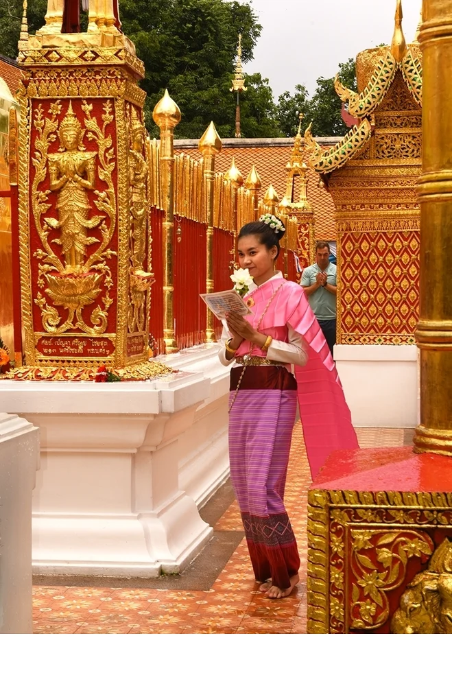 'Buddhist girl walks with offerings and prayers for Buddha to ensure her good fortune, Wat Phra That Doi Suthep temple, the most